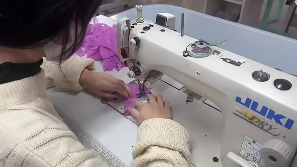 Purple lingerie fabric sewing process in a workshop