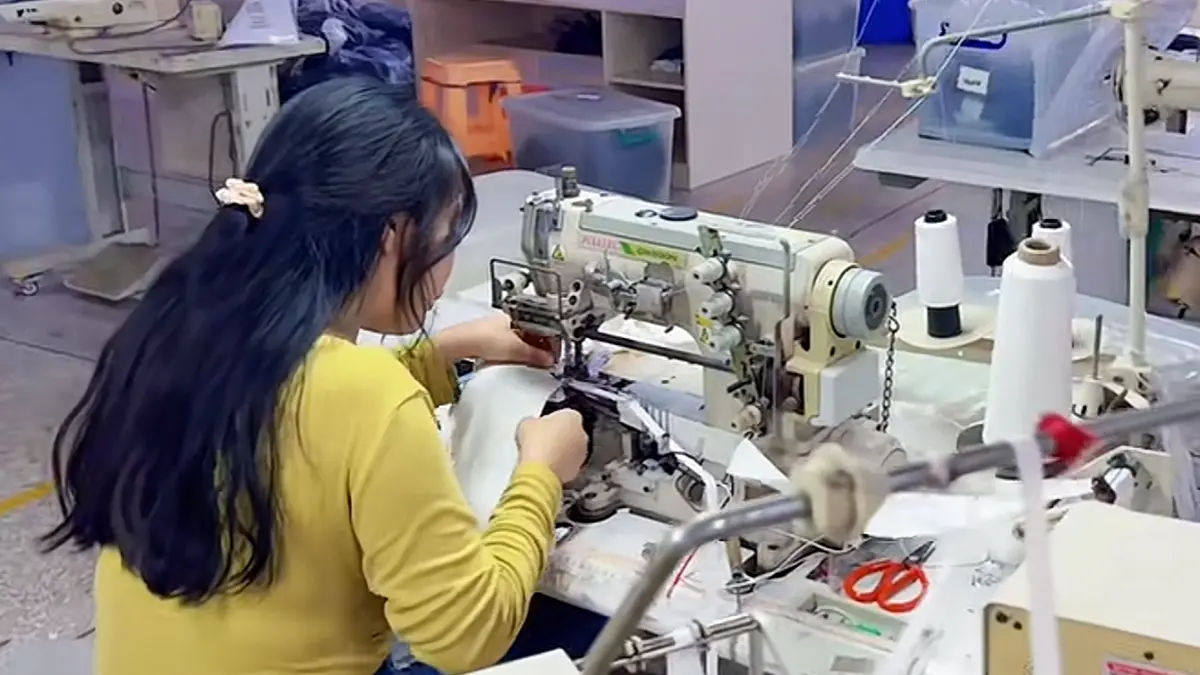 Factory sewing station with worker and production tools